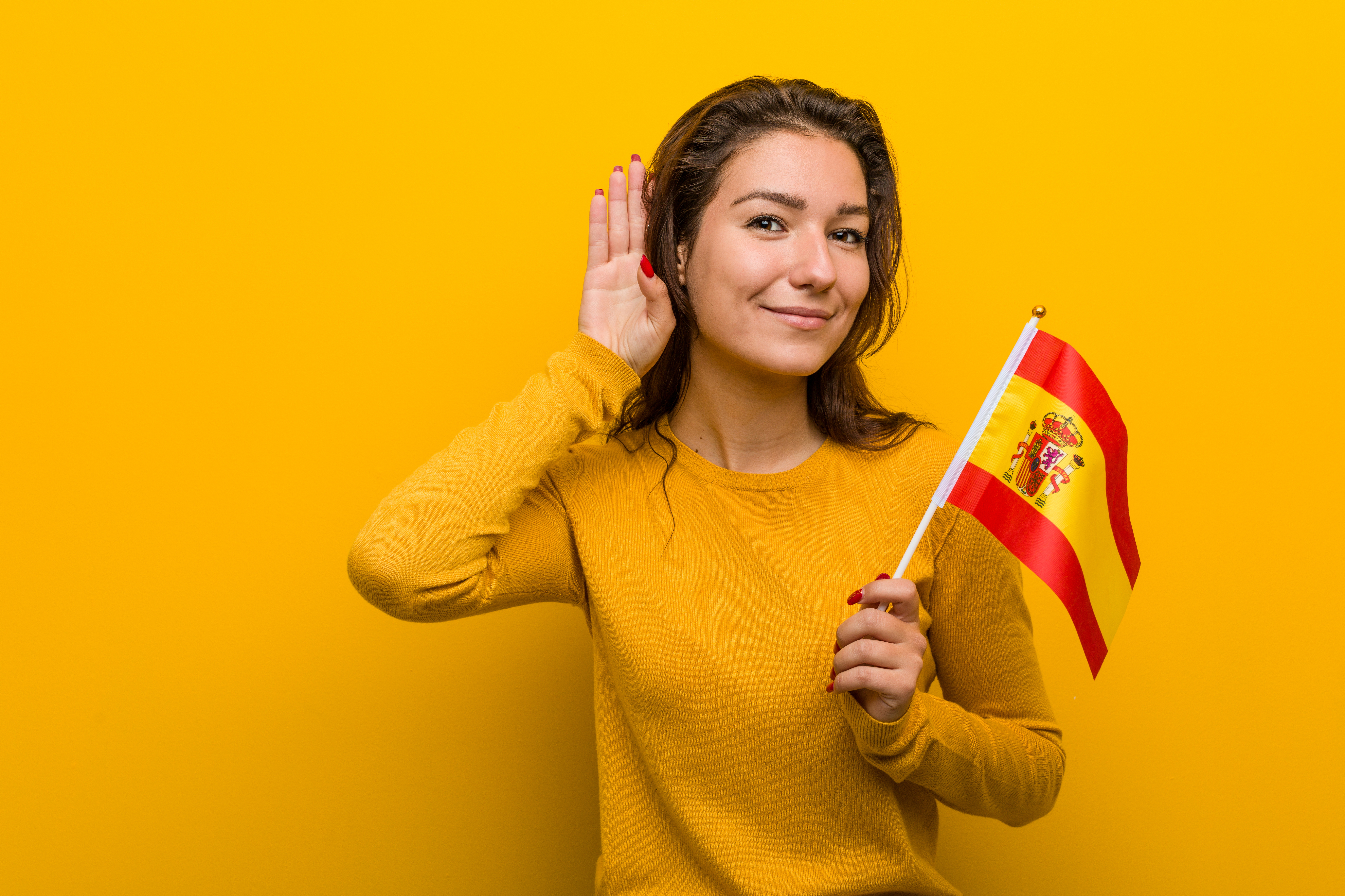 young-european-woman-holding-spanish-flag-trying-listening-gossip