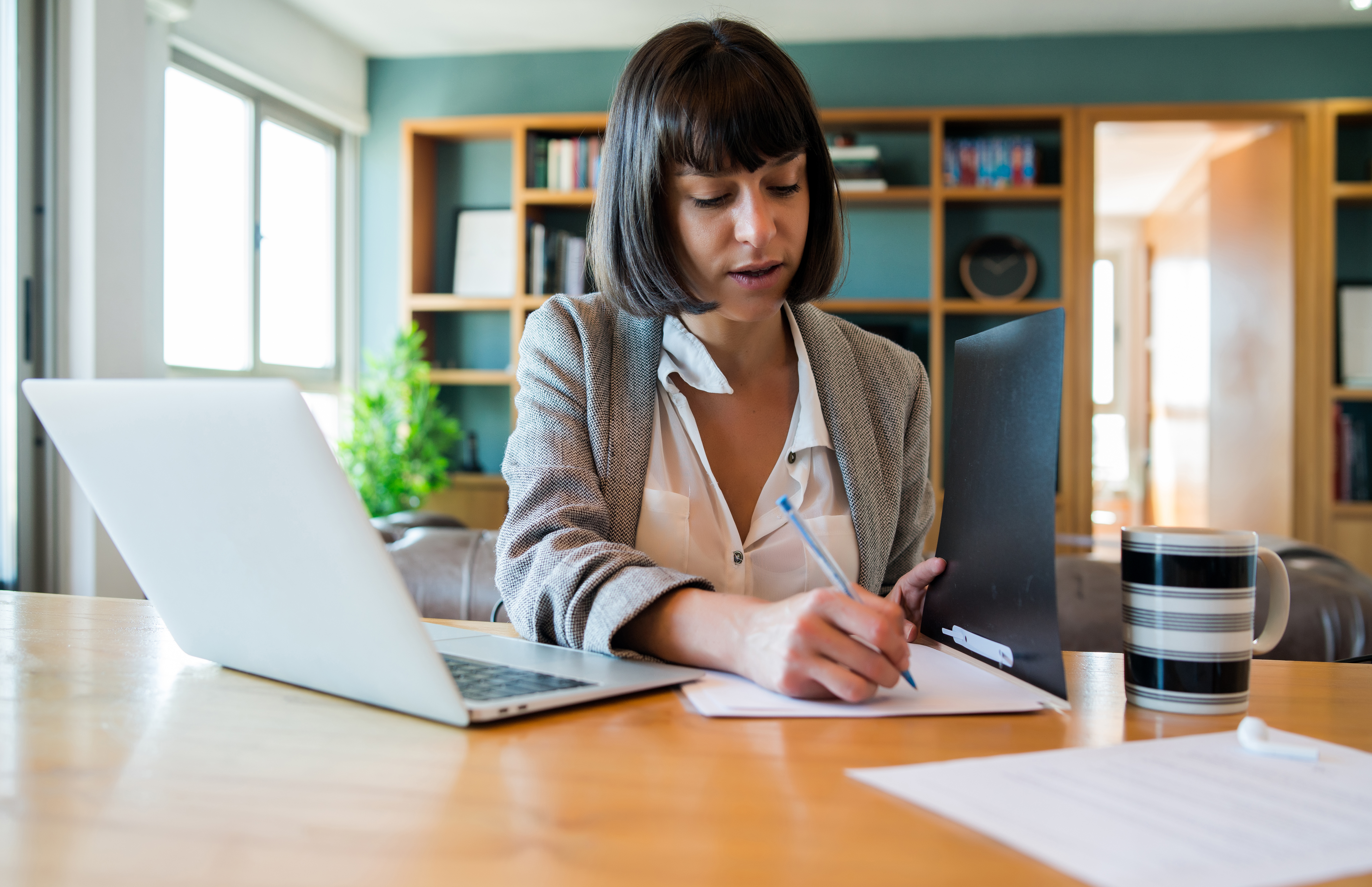 portrait-young-woman-working-from-home-with-laptop-files-home-office-concept-new-normal-lifestyle
