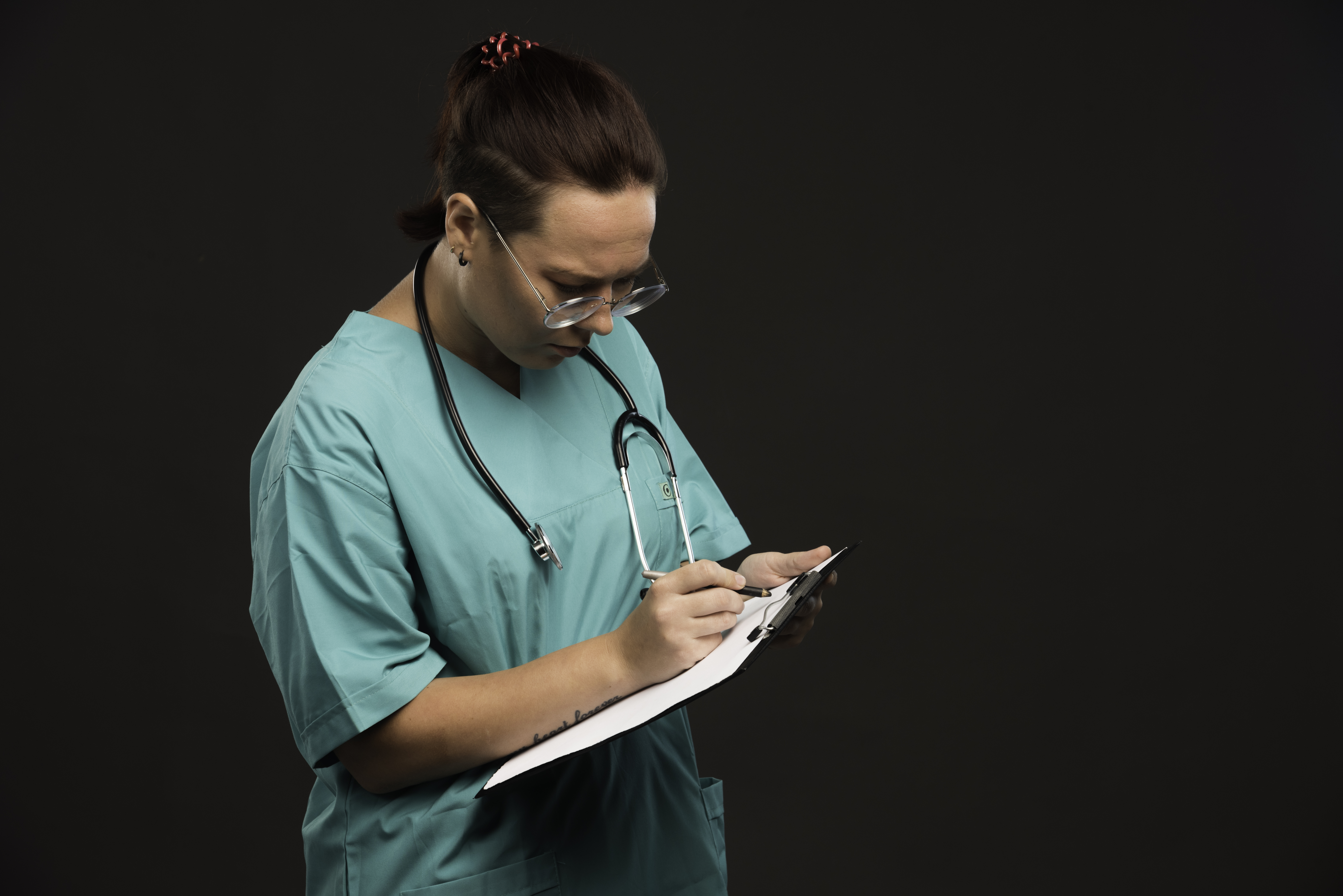 female-nurse-green-uniform-holding-blank-writing-history