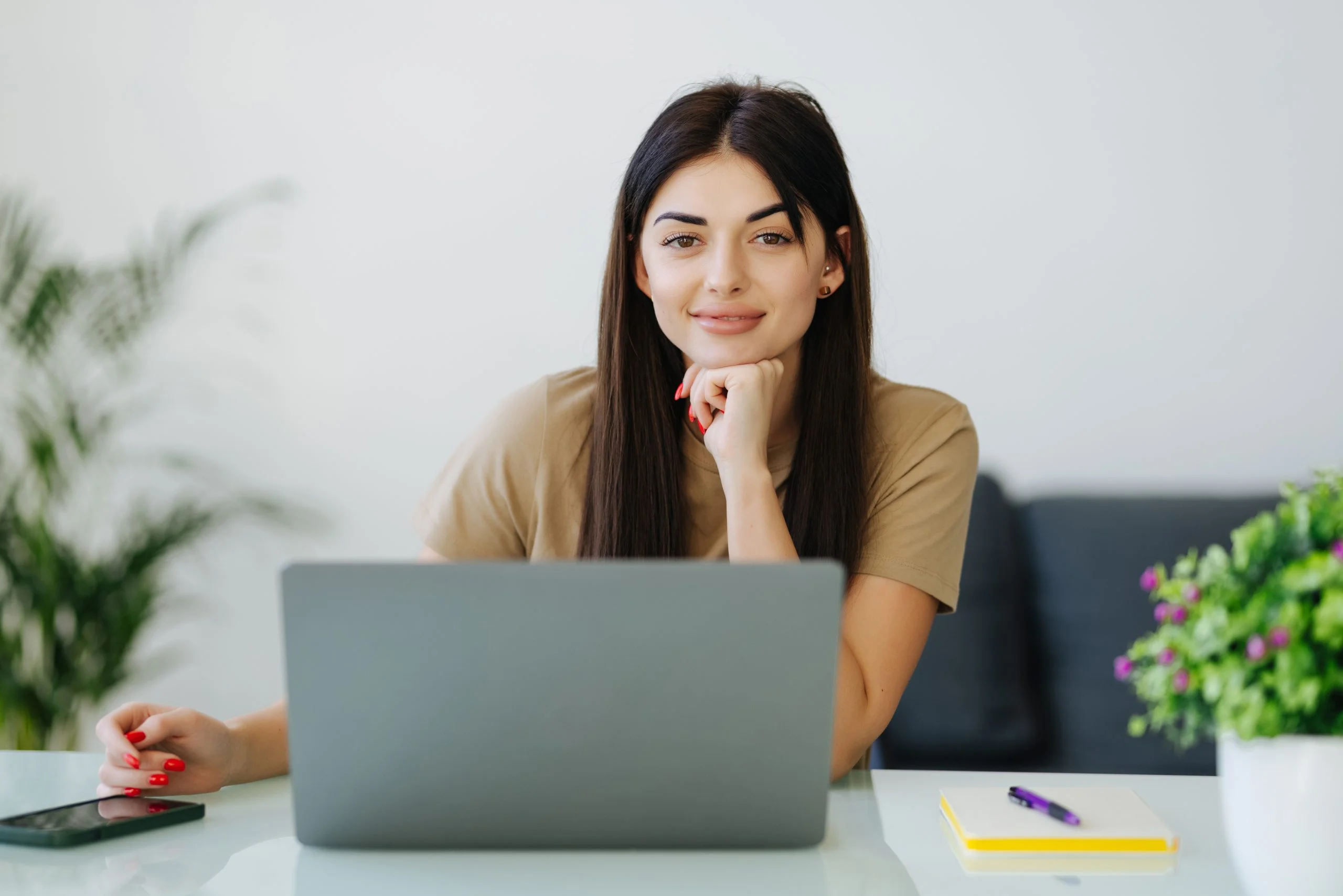 smiling-young-woman-with-laptop-home-office-scaled