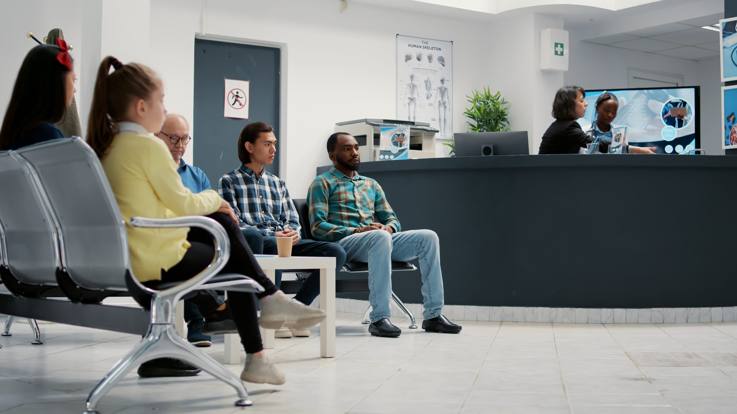 Diverse group of people waiting in hospital reception lobby