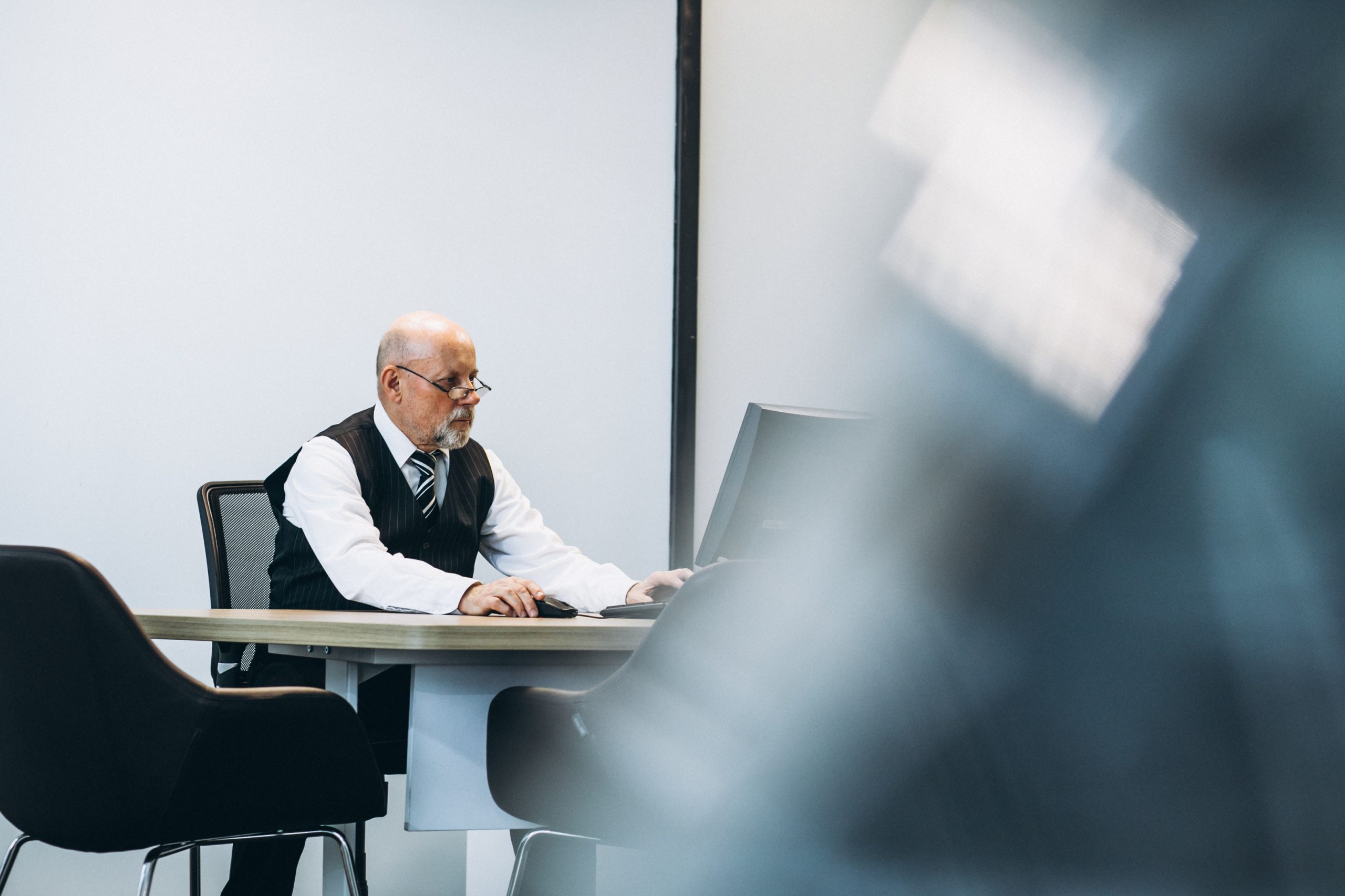 Senior manager at the office working on a computer
